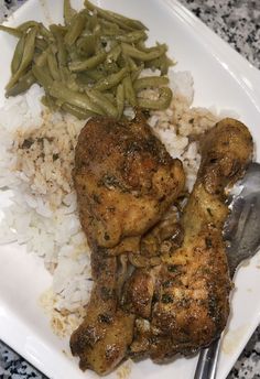 a white plate topped with rice and meat next to green beans on top of it