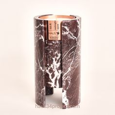 a marbled candle holder with two candles in it