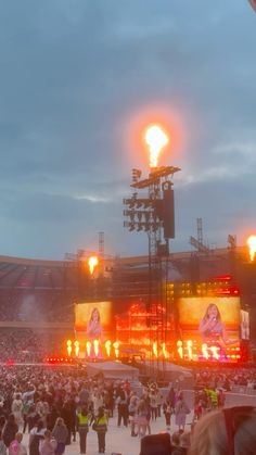 a large group of people standing on top of a field next to a stadium filled with fans