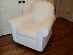 a white chair sitting on top of a hard wood floor next to a closet door