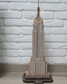 a model of the empire building is shown in front of a white brick wall