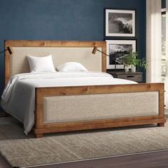 a bedroom with blue walls and white linens on the bed, along with an area rug