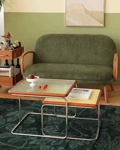 a living room with a green couch, coffee table and two end tables in it