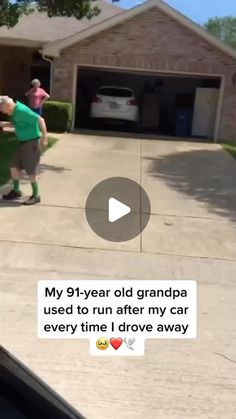 an old man is playing with his grandson in the driveway while he watches him on tv