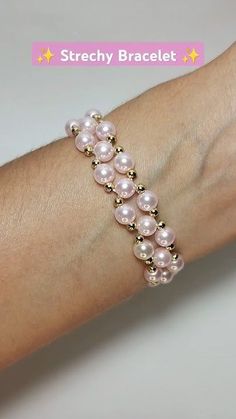 a woman's arm wearing a bracelet with pink pearls and gold beads on it