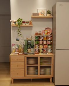 a refrigerator freezer sitting inside of a kitchen next to a wooden cabinet filled with food