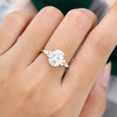 a woman's hand holding an engagement ring with two diamonds on top of it