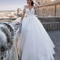 a woman in a wedding dress leaning on a wall