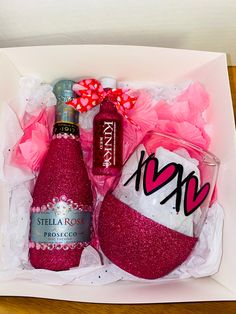 two wine bottles in a gift box with pink bows