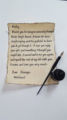 a piece of paper with writing on it next to a fountain pen and inkwell