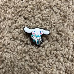 a white and blue enamel pin with an elephant on it