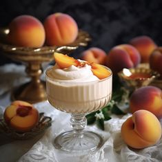 a dessert in a glass with peaches around it