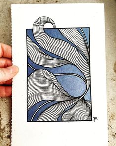 a hand holding up a blue and white print