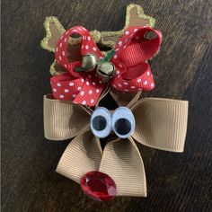 a close up of a hair bow on a wooden surface with two large blue eyes