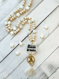 a necklace with the word miss brooke written on it and star charms attached to it