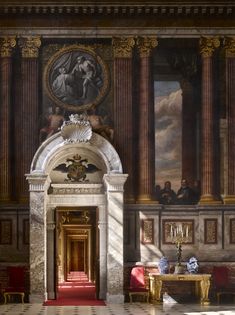 an ornately decorated room with columns and paintings on the walls