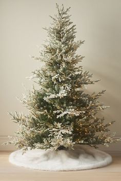 a white christmas tree with snow on the ground