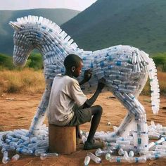 a man sitting on top of a wooden barrel next to a horse made out of plastic bottles