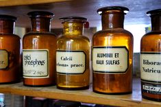 several jars are lined up on a shelf in a store, one is labeled alumini et kauli supass