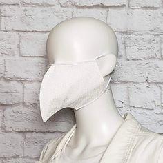 Bird beak face mask is made from two layers of 100% cotton fabric with elastic straps for behind the ears. Outer fabric is white with a subtle scroll pattern. Elastic straps include silicone adjusters for perfecting your fit. Removable nose wire included. (Note: no filter pocket.) Inner fabric may vary. Mask is lightweight and washable. Tip of mask measures approximately 3 inches from face when worn. Inside is open with no filling to impede your breathing. Since the mask is completely open insid White Cosplay Mask, White Swan Mask, White Bird Mask, White Eye Mask For Cosplay, Bird Beak Mask, Bird Beaks, Scroll Pattern, Face Mask, Beauty And Personal Care