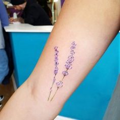 a lavender flower tattoo on the arm