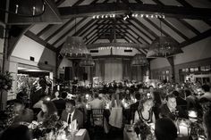 a black and white photo of people sitting at tables with candles in front of them