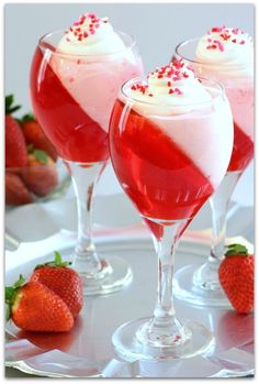 three glasses filled with liquid and topped with strawberries