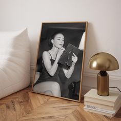 a black and white photo sitting on top of a wooden table next to a lamp