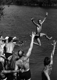 a group of men playing frisbee in the water