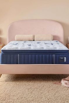 an image of a mattress on a bed frame in a room with carpet and pink walls