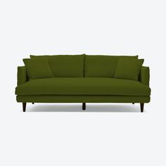 a green couch with pillows on the back and arms, in front of a white background