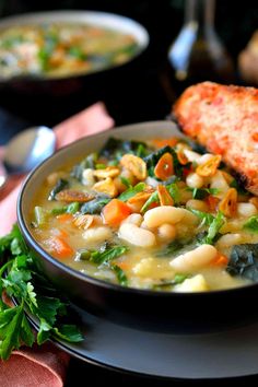 a bowl of soup with bread on the side