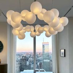 a living room filled with lots of white furniture and large windows overlooking the cityscape