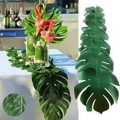 there is a vase with flowers and leaves on the table next to a tall plant