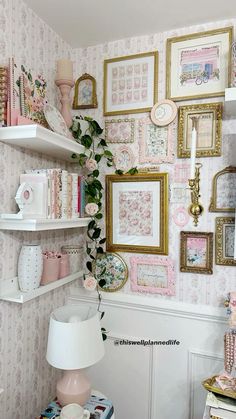 there are many pictures on the wall and shelves in this room with pink flowers, bookshelves, and other items