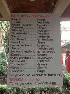 a sign that is hanging from the side of a building with words written in spanish