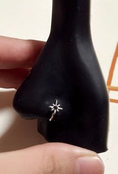 a person holding a small black object with a tiny star on it's side