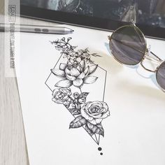 a pair of sunglasses sitting on top of a piece of paper next to some flowers