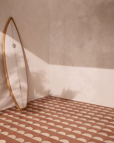 a surfboard leaning up against a wall in a room with polka dots on the floor