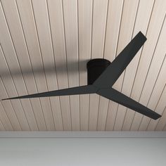 a black ceiling fan mounted to the side of a wall