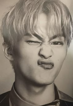 a black and white photo of a young man with his tongue out to the side