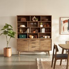 a dining room table and chairs in front of a bookshelf