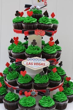 cupcakes with green frosting are stacked on top of each other in front of a sign that says las vegas