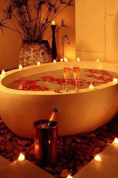 a bathtub with candles and wine glasses in it