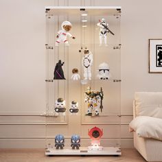 a collection of star wars action figures on display in a living room with white furniture