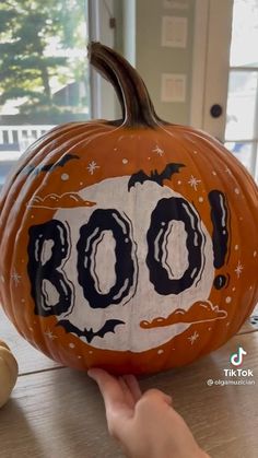 a pumpkin with the word boo painted on it