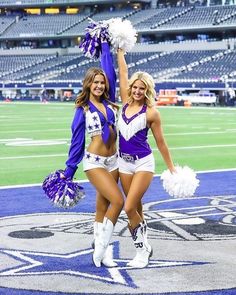 two cheerleaders standing on the field at a football game