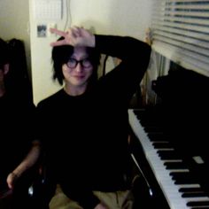 two people sitting next to each other in front of a piano