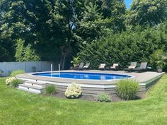 an above ground pool surrounded by grass and trees