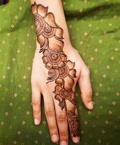 a woman's hand with henna tattoos on it